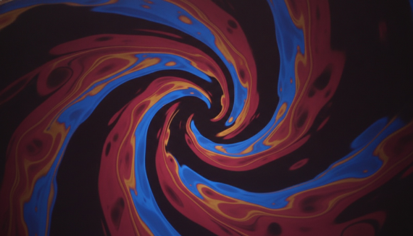 Psychedelic liquid light-show swirl in rose, gold and electric blue on black